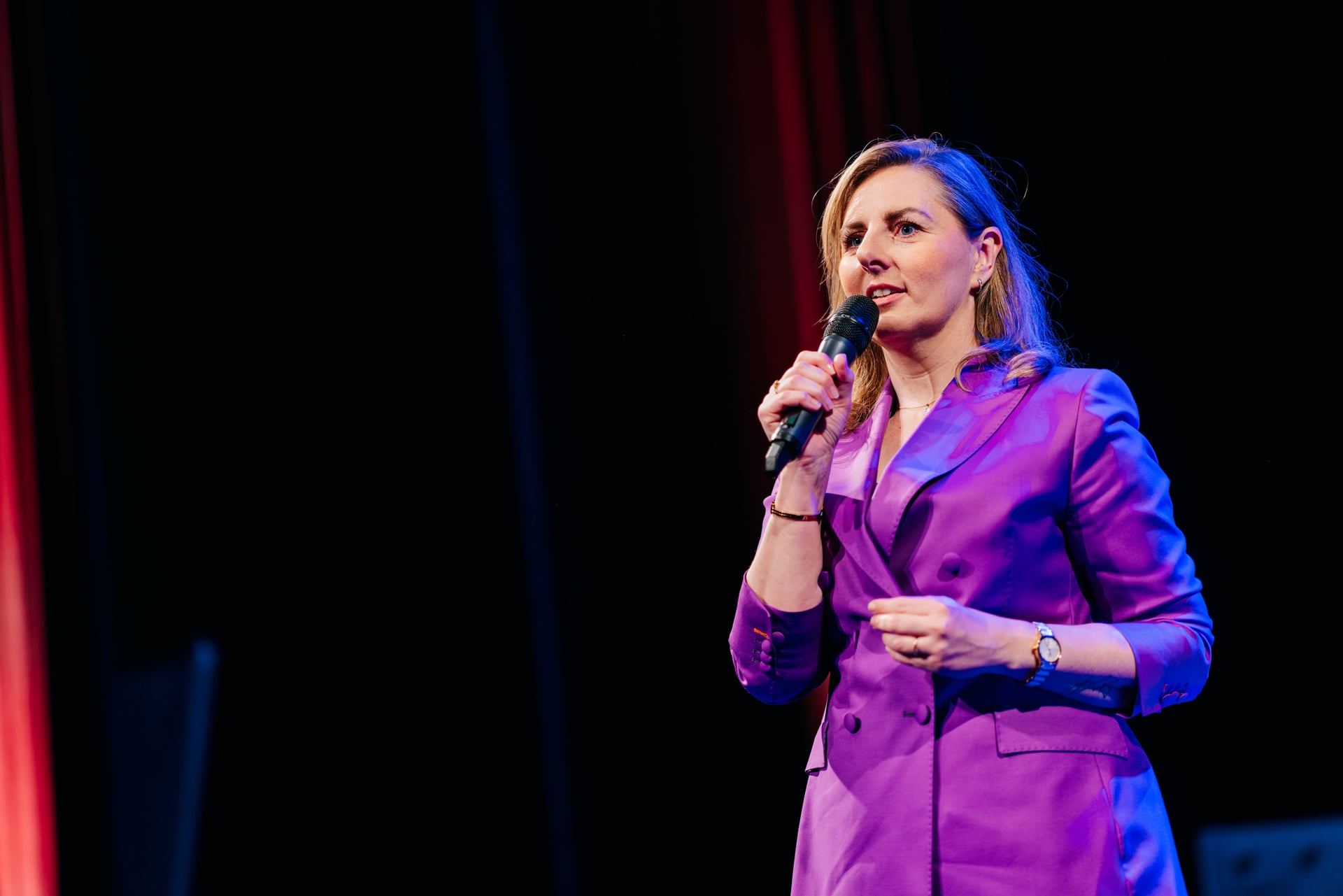Melike Durmaz op het podium met een microfoon tijdens een keynote.
